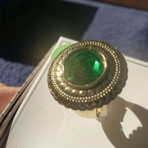 Gold tone ring with Emerald colored setting.  Size 8